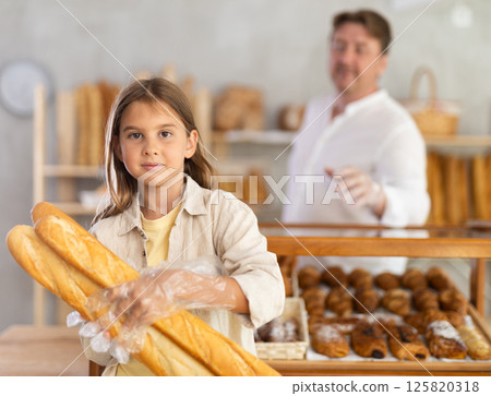 Girl in bakery chooses bread, considers various product options. 125820318