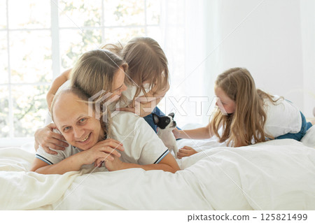Playful mother, father, girls and small dog pet at home. Happy family Playful mother, father, girls and small dog pet at home. Happy family 125821499
