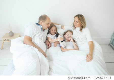 Father and mother with adorable cute children enjoying weekend at home Father and mother with adorable cute children enjoying weekend at home 125821501