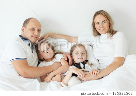 Happy family relaxing on the couch together at home Happy family relaxing on the couch together at home 125821502