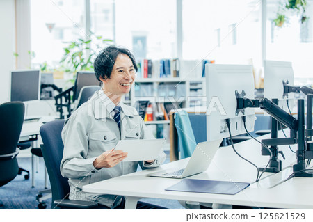 一名身穿工作服的年輕人在公司工作 125821529