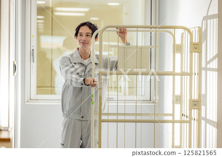 一名身穿工作服的男子搬運貨櫃 125821565