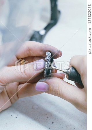 Crafting precise metal dentures by skilled dental technician in workshop Crafting precise metal dentures by skilled dental technician in workshop 125822088