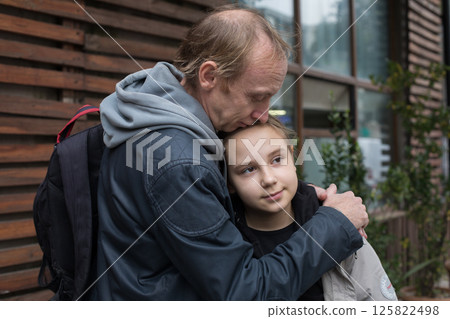 Caring father kissing his daughter child girl outdoors. Happy family outdoors portrait 125822498