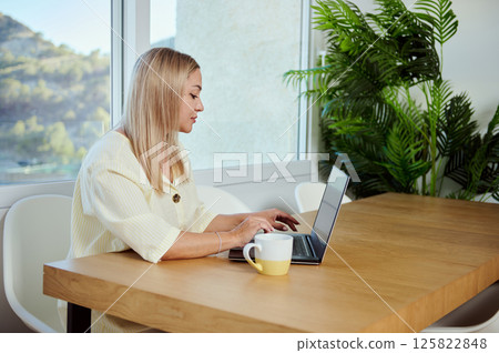 Focused Professional Woman Using Laptop in Bright Modern Office Interior 125822848