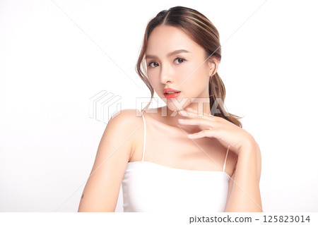 A beautiful young Asian woman with clean, fresh skin against a white background. Skincare, facial treatment, cosmetology, beauty, and spa. An elegant portrait of an Asian woman. 125823014