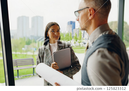 A business meeting is taking place among professionals in a modern and stylish office space A business meeting is taking place among professionals in a modern and stylish office space 125823312