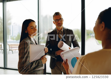 A Business Meeting where Professionals are Discussing Various Charts and Detailed Reports 125823330