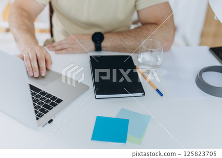 Close up, business man using mobile smart phone and and makes notes in a notebook. makes an appointment, conducts a consultation, social network 125823705