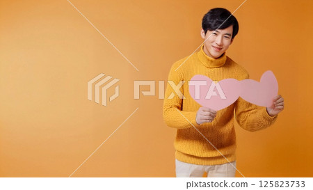 Photo with copy space of a man holding a paper heart and wondering in front of a valentine 125823733