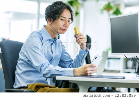 一名男子在辦公室吃蛋白棒 125823859