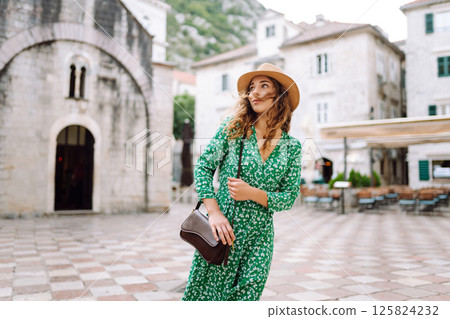 Young woman in beautiful dress walking in the street of the city. Eurotrip. Travel, tourism. Fashion Young woman in beautiful dress walking in the street of the city. Eurotrip. Travel, tourism. Fashion 125824232