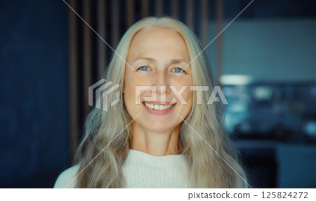 Portrait of beautiful happy smiling mature woman looking at camera in room at home Portrait of beautiful happy smiling mature woman looking at camera in room at home 125824272