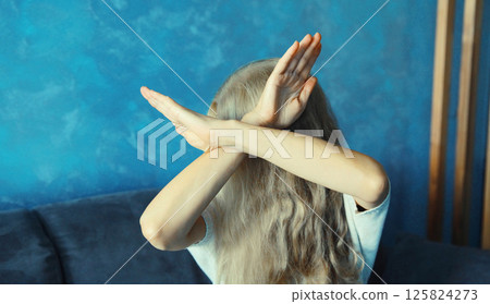 Woman shows stop, no or enough sign with palm of hand, refusal gesture, domestic violence 125824273