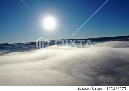 Aerial view of fog blankets during a bright winter morning under a clear blue sky 125824375