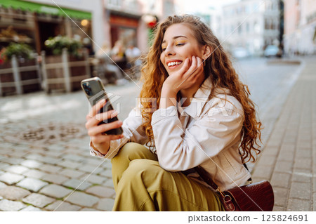Happy woman using phone walking in city street. Lifestyle, travel, tourism, technology, blogging 125824691