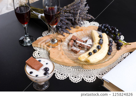 Romantic dessert setting with fruit, chocolate, yogurt, and drinks. 125824826