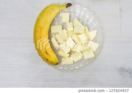 Banana and diced white confection on a glass plate. Banana and diced white confection on a glass plate. 125824837