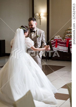 A bride and groom share a tender first dance at their wedding reception. 125824913