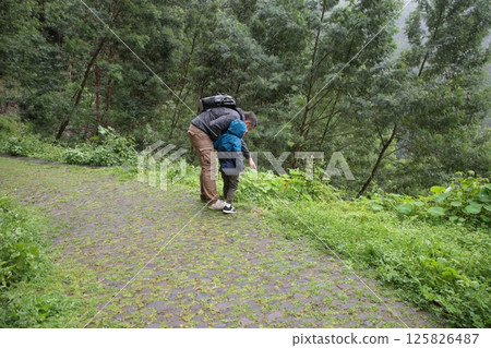 Father and son exploring nature on a cobblestone path Father and son exploring nature on a cobblestone path 125826487