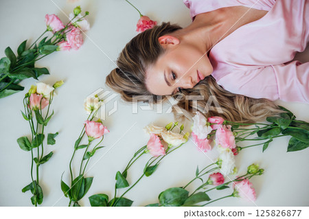 woman in summer pink dress lying among flowers woman in summer pink dress lying among flowers 125826877