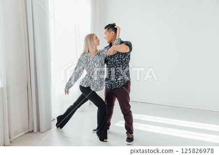 Man and woman dancing together to music Man and woman dancing together to music 125826978