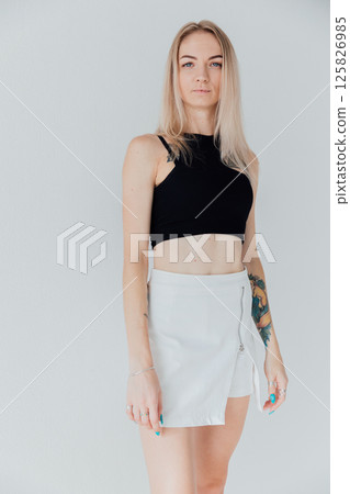 Portrait of a blonde woman in a skirt on a white background Portrait of a blonde woman in a skirt on a white background 125826985