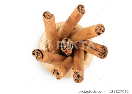 Cinnamon sticks in wooden bowl isolated on white background with full depth of field. Top view. Flat lay. 125827011