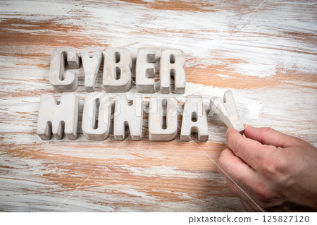 Cyber Monday. Concrete alphabet letters on a light painted wood texture background Cyber Monday. Concrete alphabet letters on a light painted wood texture background 125827120