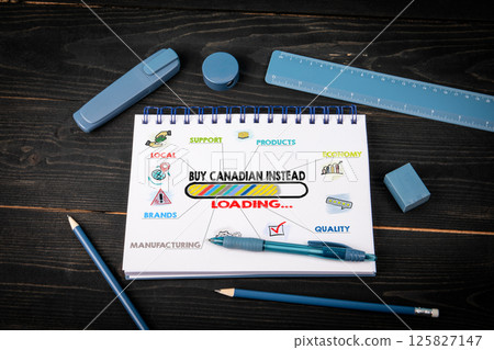 Buy Canadian Instead Loading. Notepad and blue stationery on a black wooden texture background Buy Canadian Instead Loading. Notepad and blue stationery on a black wooden texture background 125827147