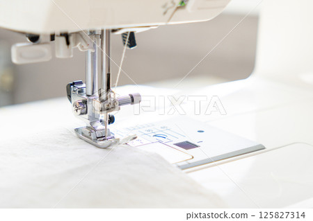 sewing machine with a cloth under a steel needle. manufacture of clothing. sewing machine with a cloth under a steel needle. manufacture of clothing. 125827314