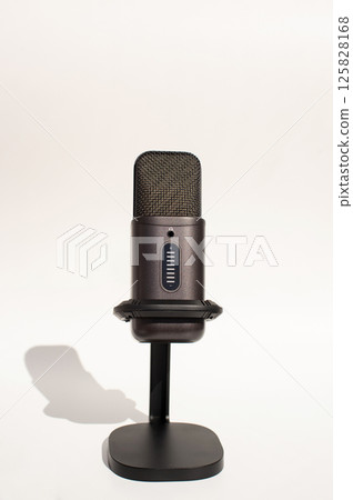 Black condenser microphone on stand with shadow 125828168