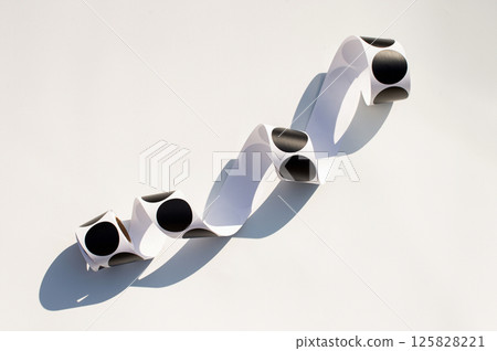 Curved paper with black circles and shadow on white background Curved paper with black circles and shadow on white background 125828221
