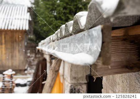 Rural snow-covered roofs in a winter landscape Rural snow-covered roofs in a winter landscape 125828241