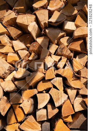 Stack of chopped firewood in sunlight Stack of chopped firewood in sunlight 125828248