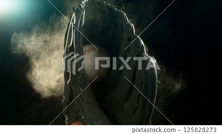 Hand in brown leather baseball glove caught ball isolated on black background 125828273