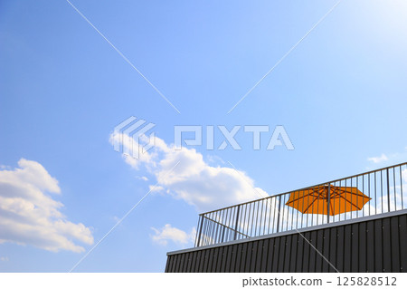 Blue sky and rooftop umbrellas Blue sky and rooftop umbrellas 125828512