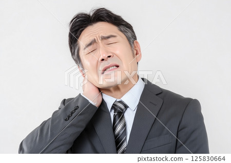 一位中年男性商人頸部和肩膀僵硬的臉部表情 125830664