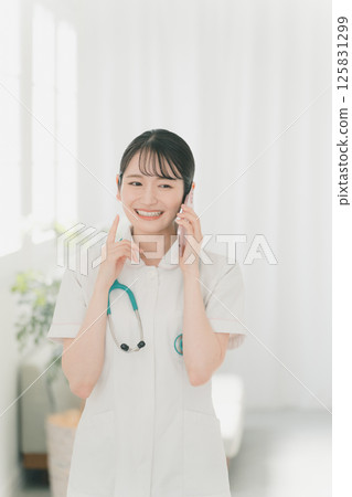 Young nurse and smartphone 125831299