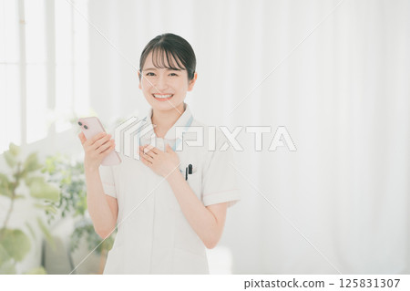 Young nurse and smartphone 125831307