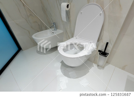 A modern toilet with neat paper protection in a clean white bathroom 125831687