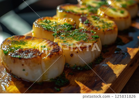 Golden Grilled Scallops Drizzled with Lemon Butter on Rustic Board in Sunlight 125831826