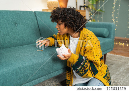 Saving money investment for future. African American girl holding pink piggy bank and putting money coin. Saving investment budget business wealth retirement financial money banking concept Saving money investment for future. African American girl holding pink piggy bank and putting money coin. Saving investment budget business wealth retirement financial money banking concept 125831859