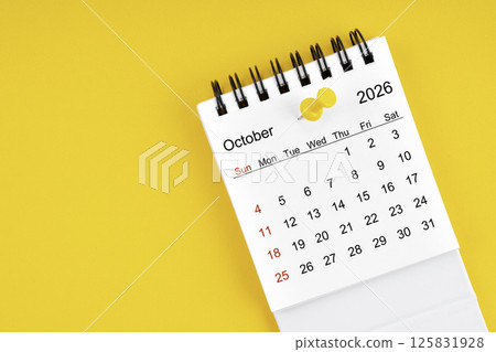 October 2026 Monthly desk calendar for 2026 year with thumbtack on yellow background. 125831928