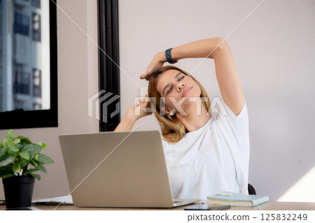 Portrait young caucasian businesswoman taking a break after overworked with stretching arm. 125832249