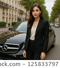 A young woman standing in front of a car 125833797