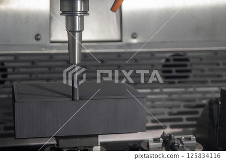 The CNC milling machine rough cutting the graphite electrode parts with solid flat nose end mill tool. 125834116