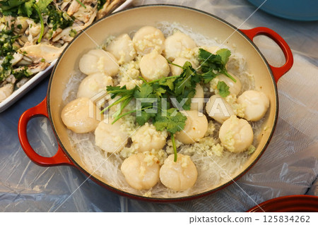 close up of homemade Chinese steamed scallop and Cellophane noodles with garlic and parsley as toppings in a pot  125834262