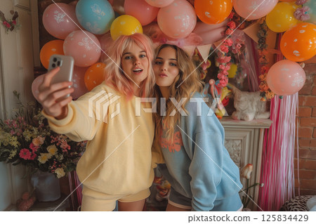Teens in pastels take Easter selfies surrounded by festive balloons and garlands 125834429