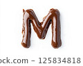 Stylized chocolate drizzle shaped like the letter m on white background for creative design 125834818